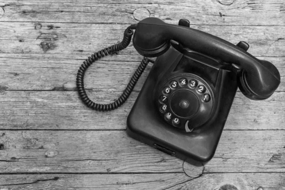 Old telephone on wooden background,  black and white — Stock Photo, Image