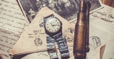 Military lighter with wrist watches lying on military photographs and letters — Photo by Moriak_marginal
